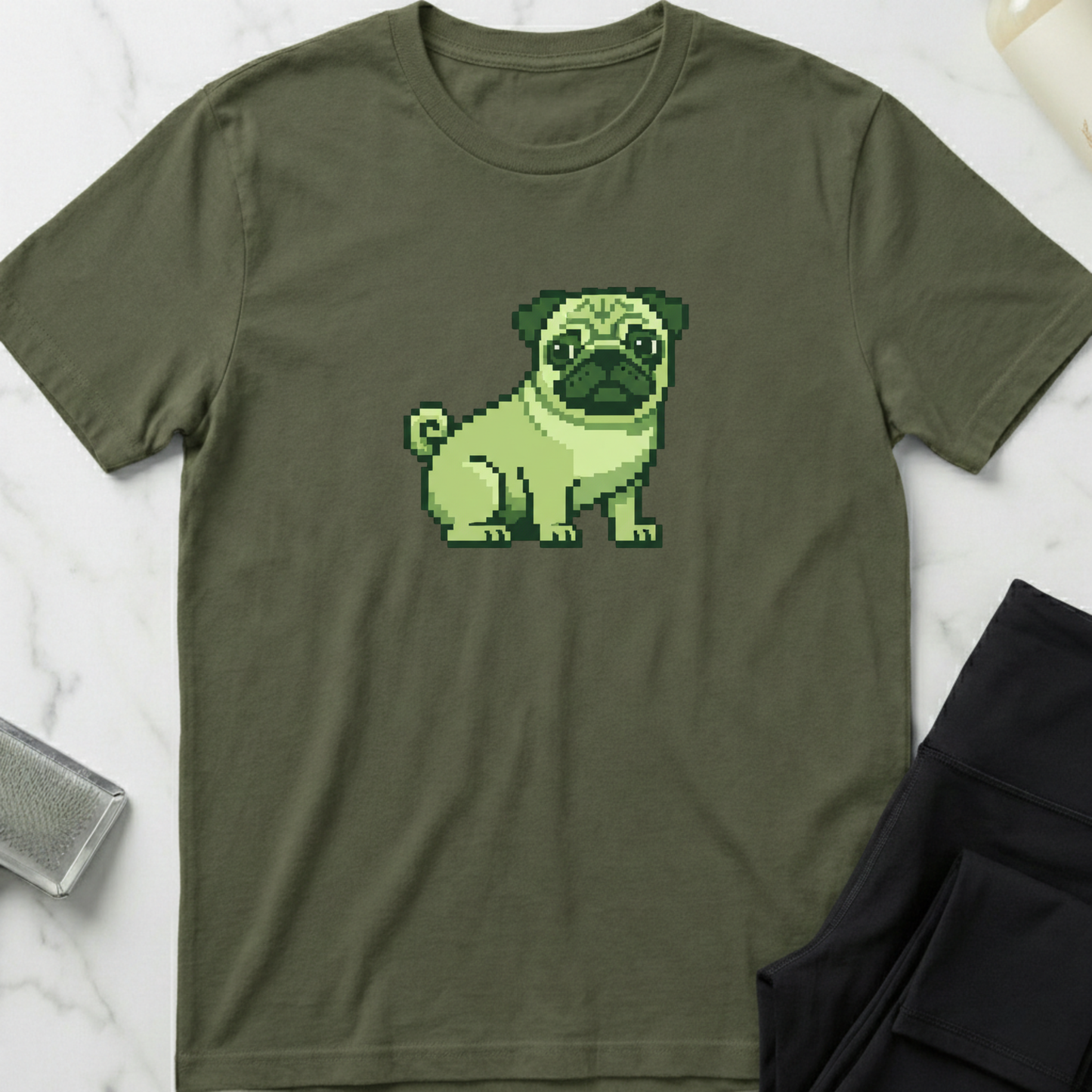 Green t-shirt with a pixelated pug design on a marble surface. Minimalist dog apparel by pemuyo.