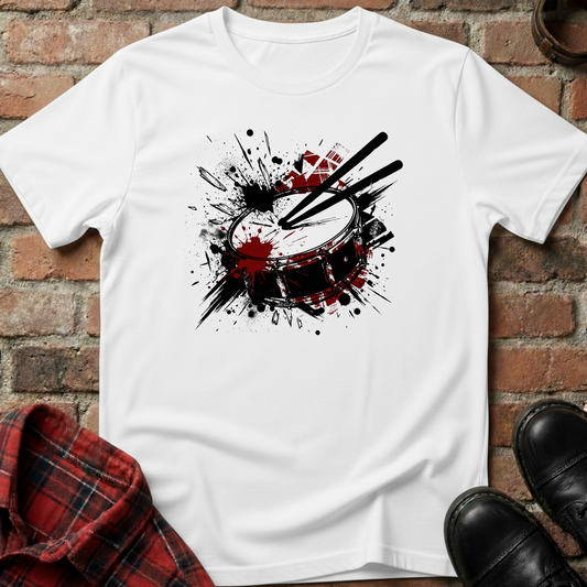 White t-shirt with drum design on a brick surface. Minimalist music apparel by pemuyo.