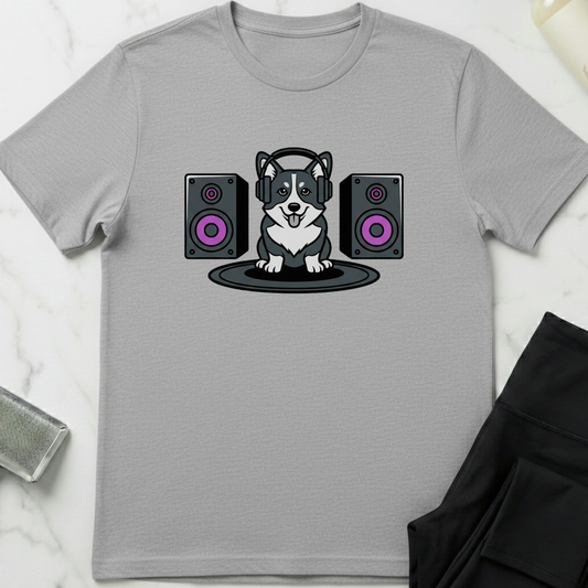 Gray t-shirt with a dog wearing headphones and speakers design on a white marble surface. Minimalist dog apparel by pemuyo.