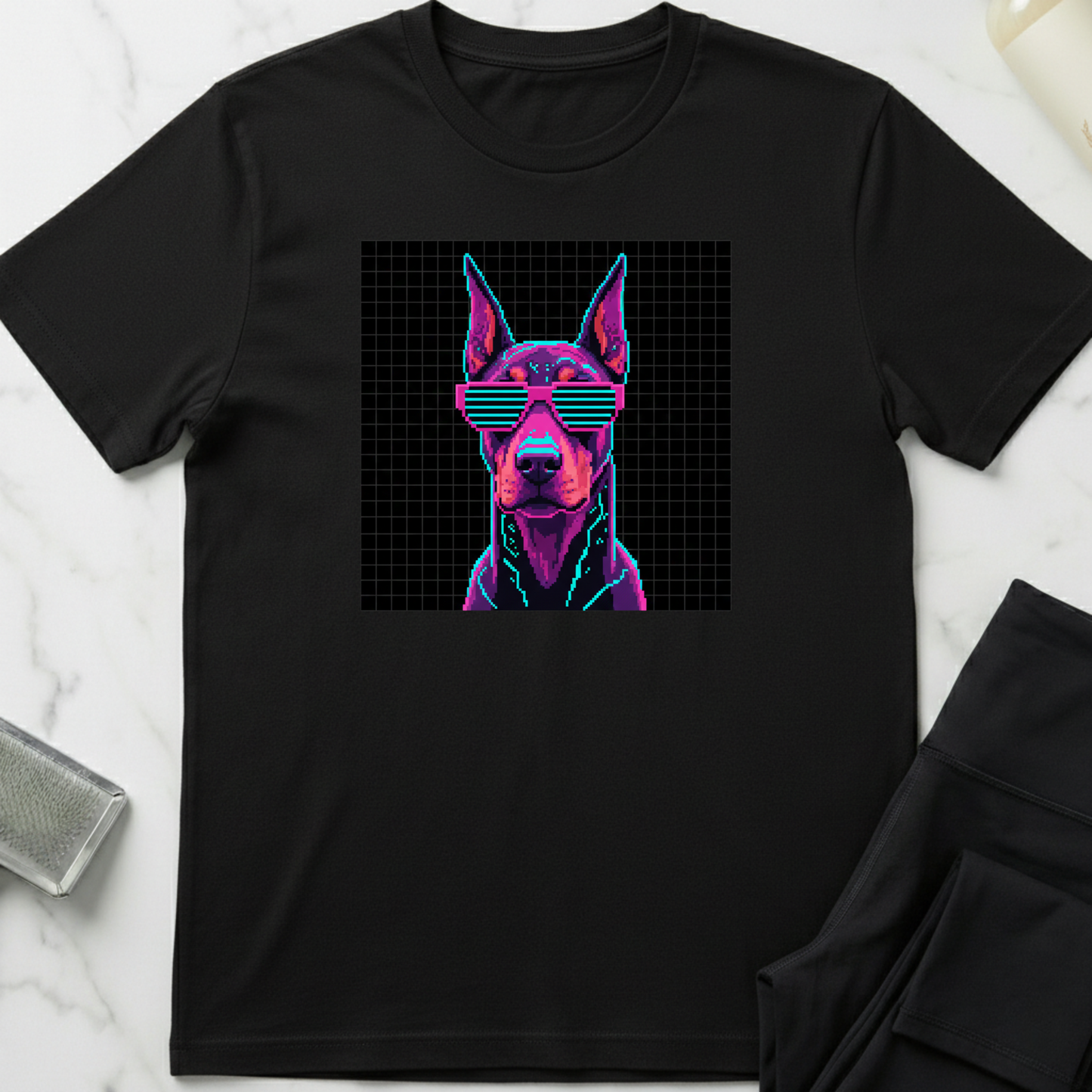 Black t-shirt with a dog graphic wearing sunglasses on a white marble surface. Minimalist dog apparel by pemuyo.