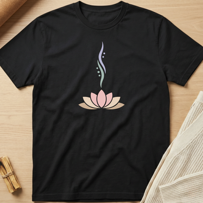 Black t-shirt with a pink lotus flower design on a wooden surface. Minimalist yoga apparel by pemuyo.