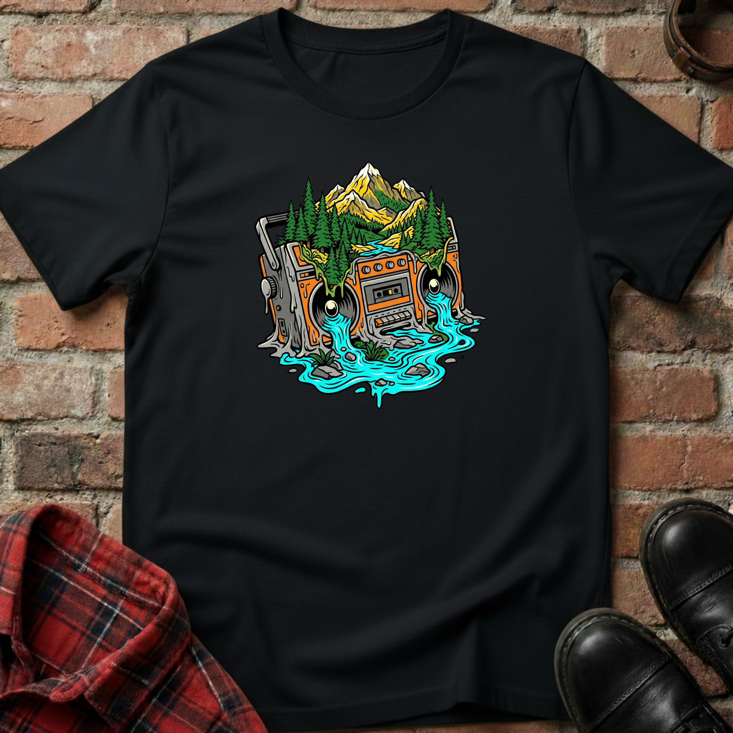 Black t-shirt with a graphic design of a mountain and cassette tape on a brick wall background. Minimalist music apparel by pemuyo.