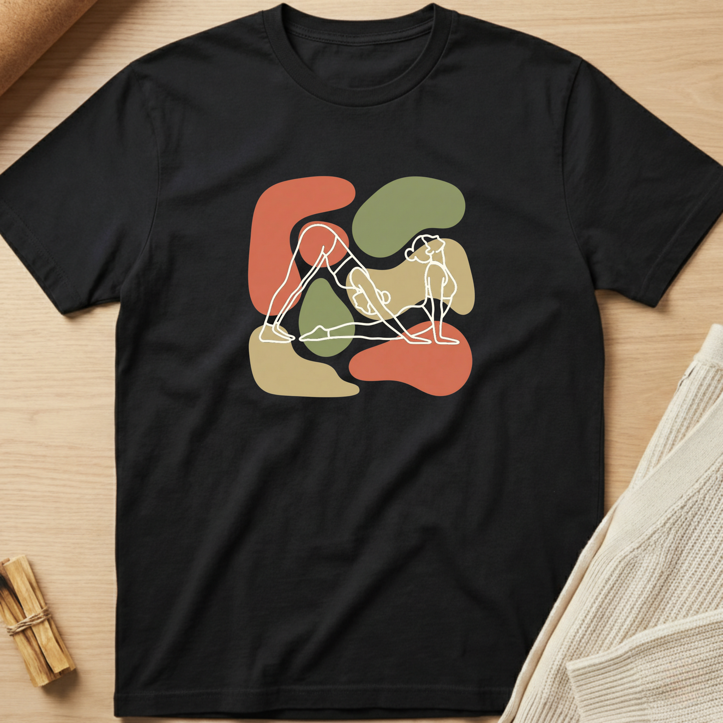 Black t-shirt with abstract design on a wooden surface. Minimalist yoga apparel by pemuyo.