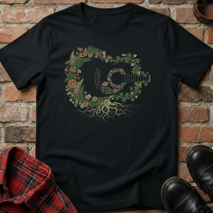 Black t-shirt with a guitar design made of leaves and flowers on a brick background. Minimalist music apparel by pemuyo.