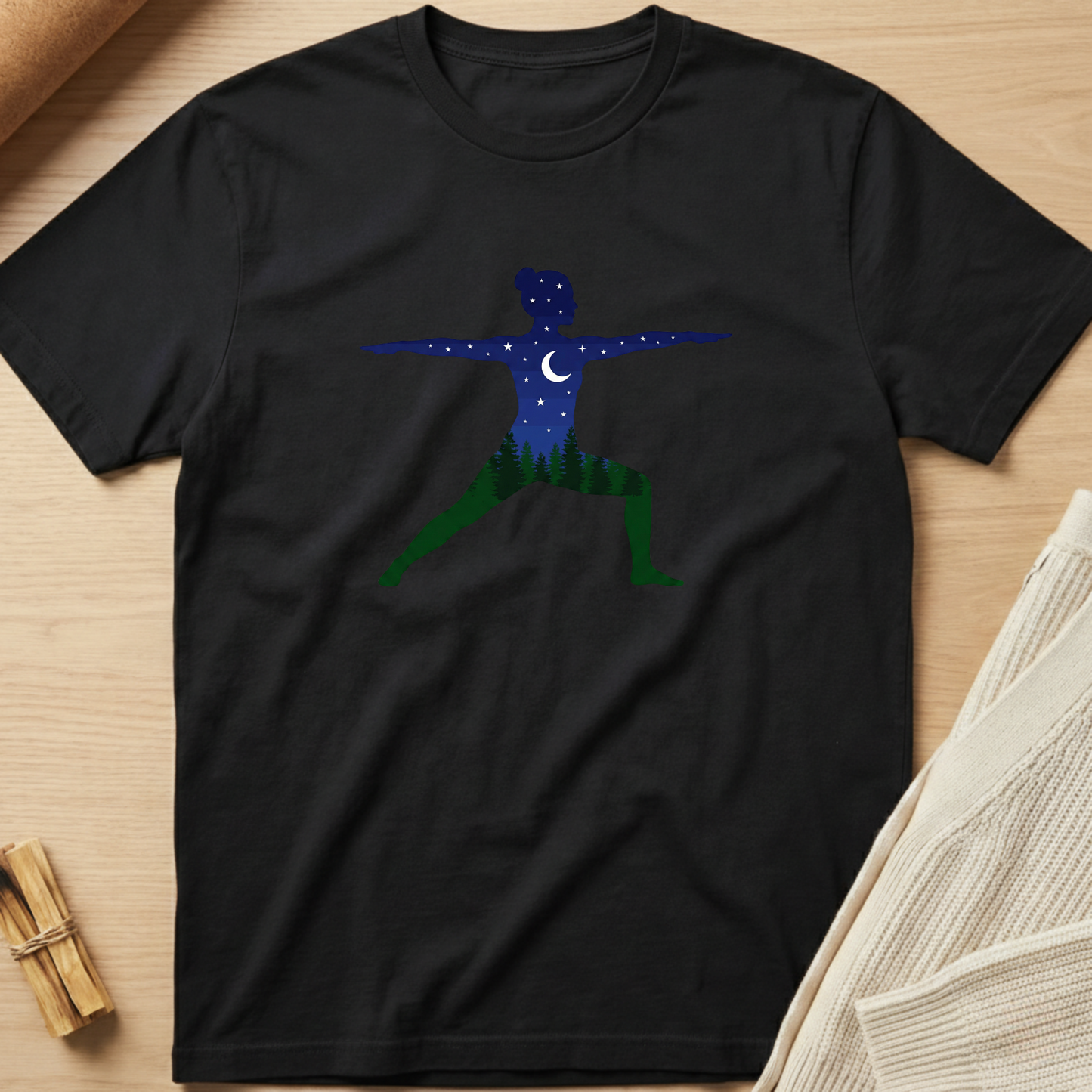 Black t-shirt with a blue and green graphic design on a wooden surface. Minimalist yoga apparel by pemuyo.