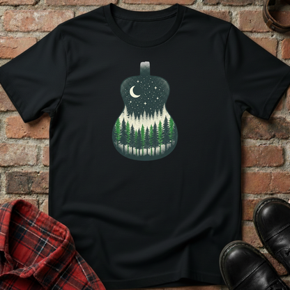 Black t-shirt with a forest design in a guitar shape against a brick wall. Minimalist music apparel by pemuyo.