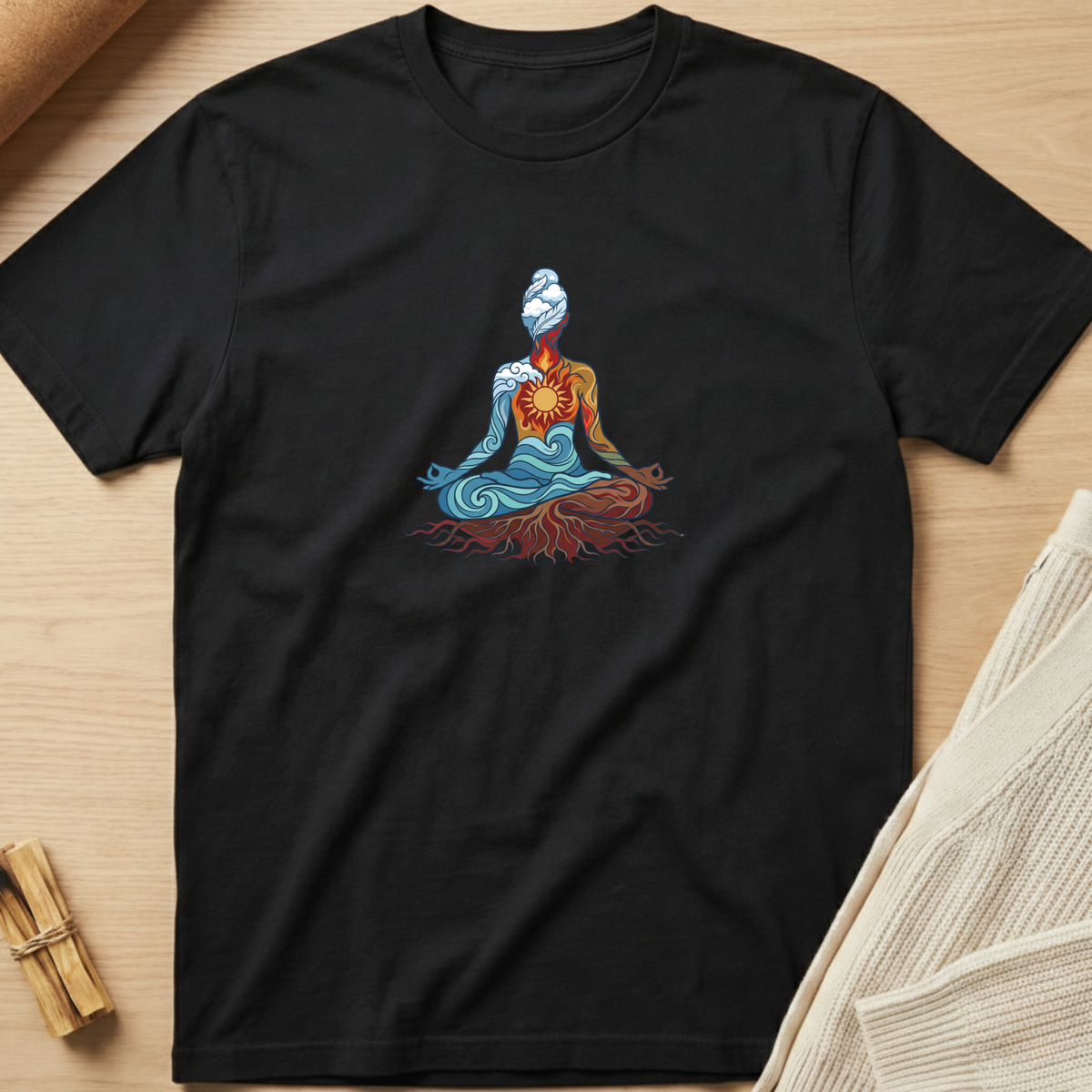 A black short-sleeve crewneck t-shirt laid flat on a light wood surface, featuring a colorful graphic of a meditating figure with blue, orange, and red details. Minimalist yoga apparel by pemuyo.