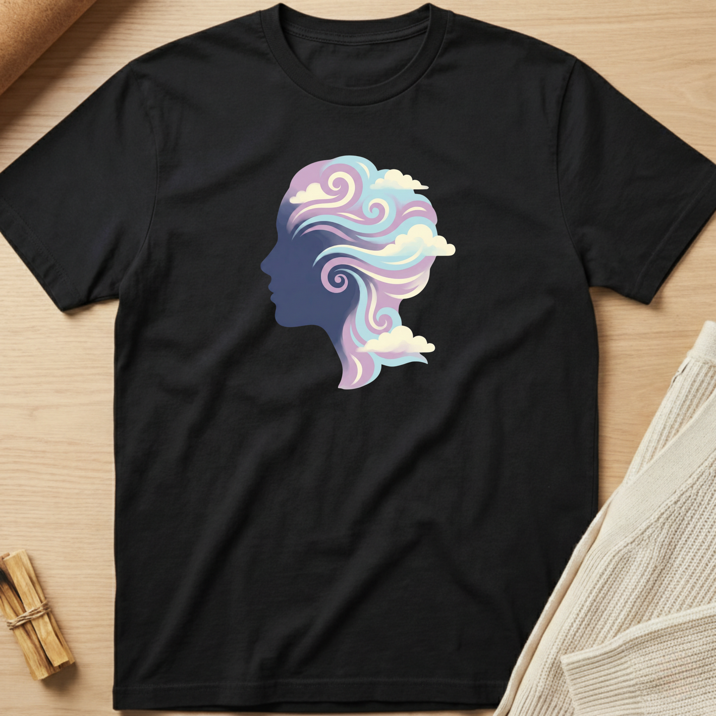 Black t-shirt with a colorful silhouette design of a head on a wooden surface. Minimalist yoga apparel by pemuyo.