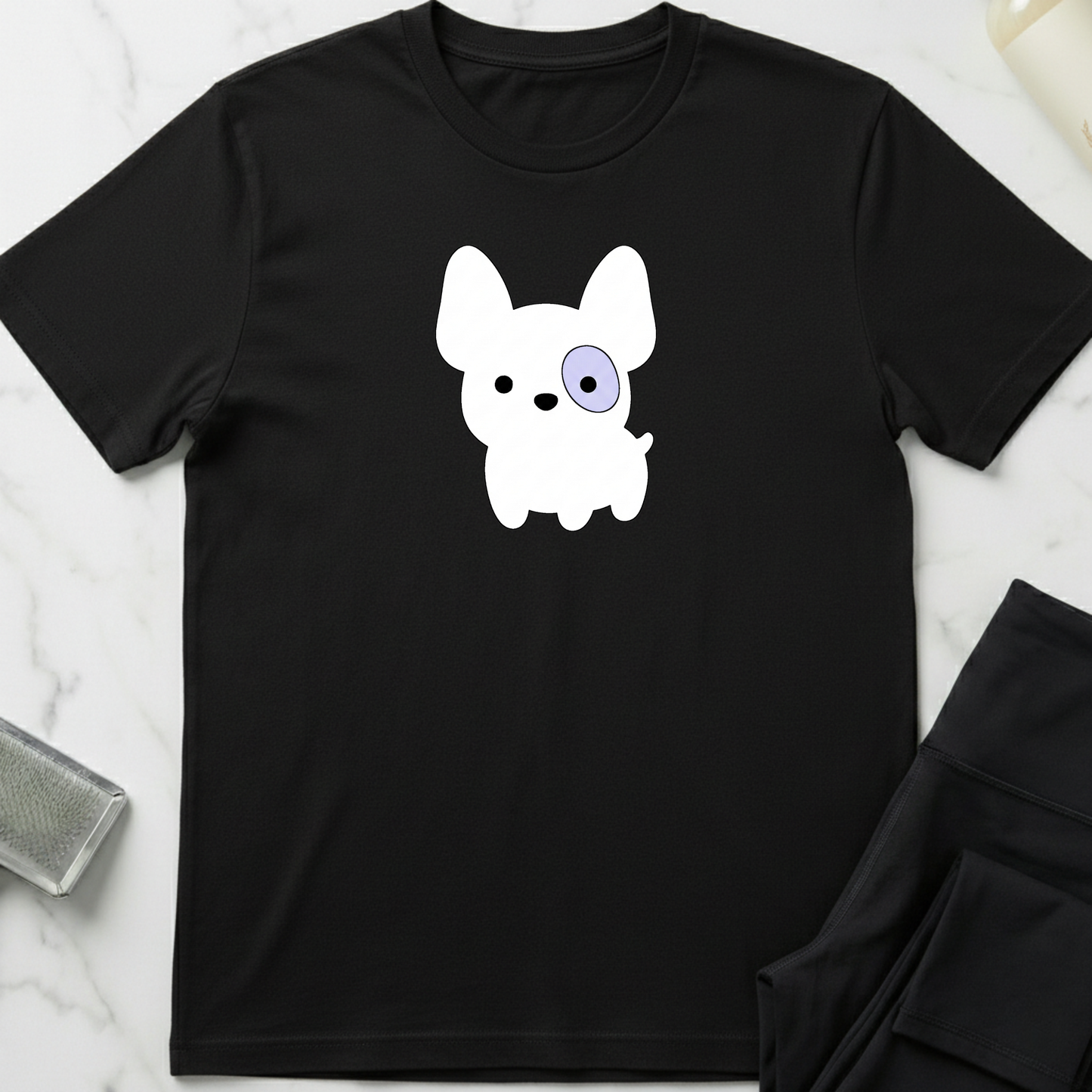 Black t-shirt with a white dog graphic on a marble surface. Minimalist dog apparel by pemuyo.