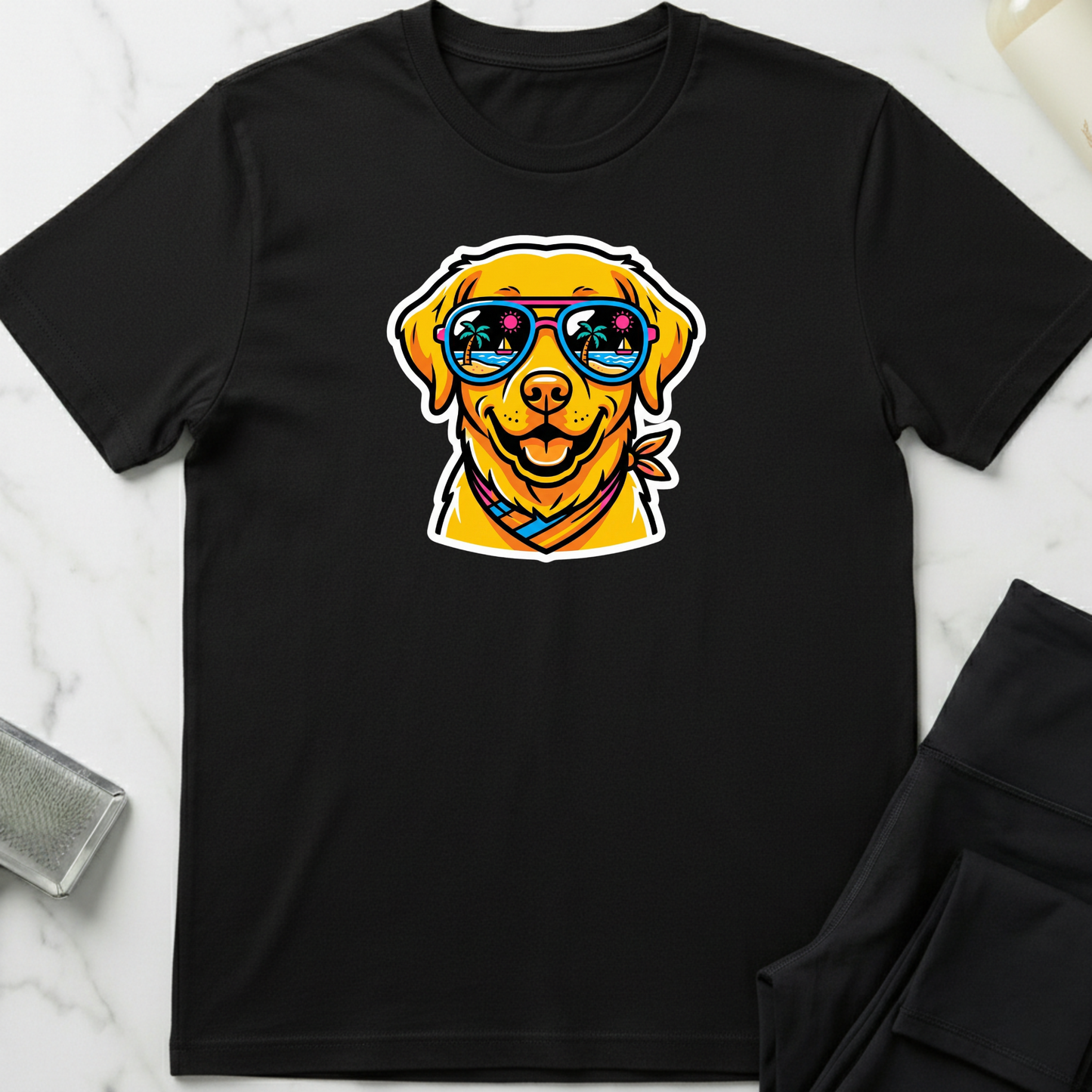 Black t-shirt with a dog wearing sunglasses graphic on a marble surface. Minimalist dog apparel by pemuyo.