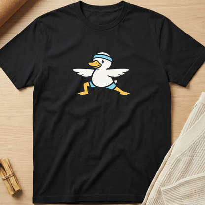 Black t-shirt with a cartoon duck design on a wooden surface. Minimalist yoga apparel by pemuyo.