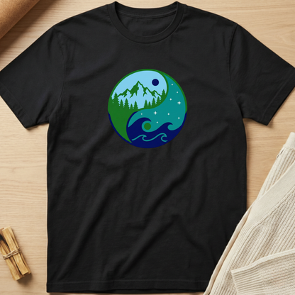 Black t-shirt with a circular design featuring nature elements on a wooden surface. Minimalist yoga apparel by pemuyo.