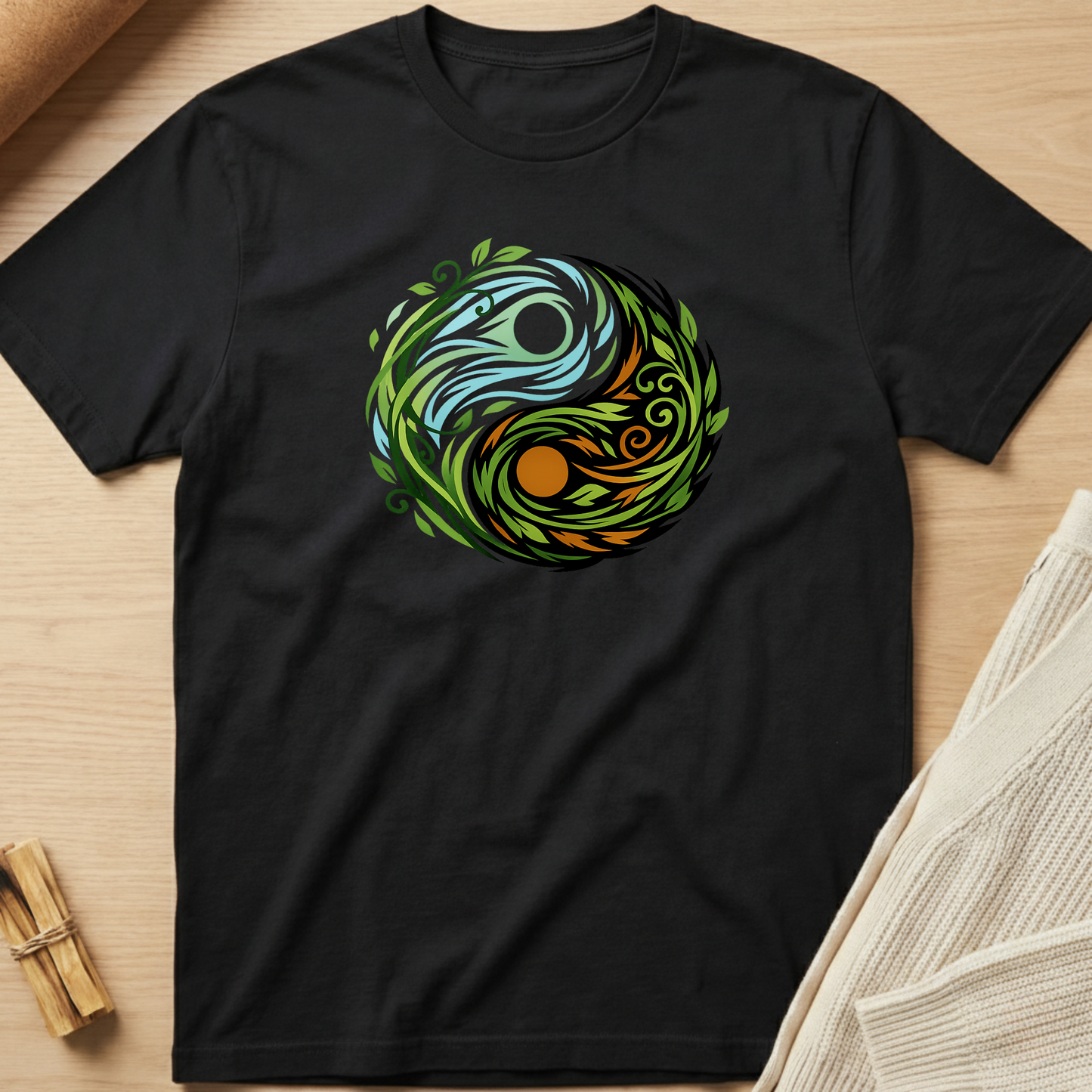 Black t-shirt with a colorful circular design on a wooden surface. Minimalist yoga apparel by pemuyo.