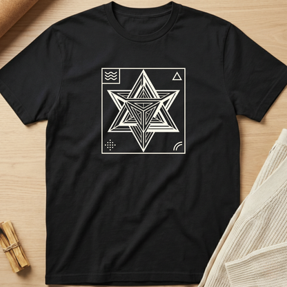 Black t-shirt with a white geometric star design on a wooden surface. Minimalist yoga apparel by pemuyo.
