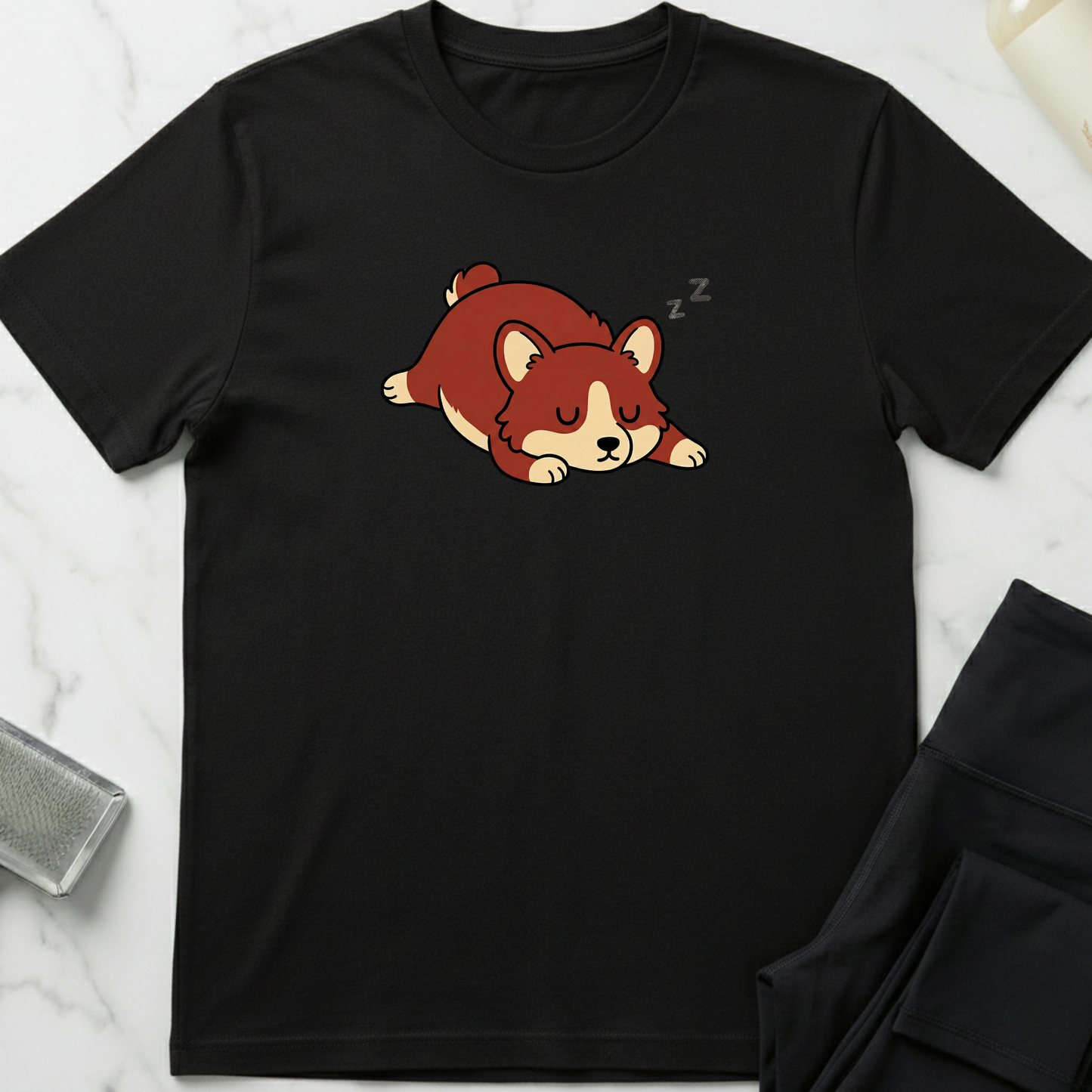 Black t-shirt with a cartoon dog design on a marble surface. Minimalist dog apparel by pemuyo.