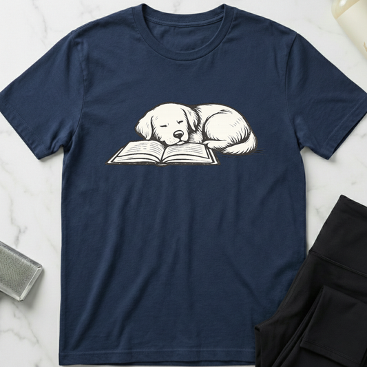 Navy blue t-shirt with a dog reading a book graphic on a marble surface. Minimalist dog apparel by pemuyo.