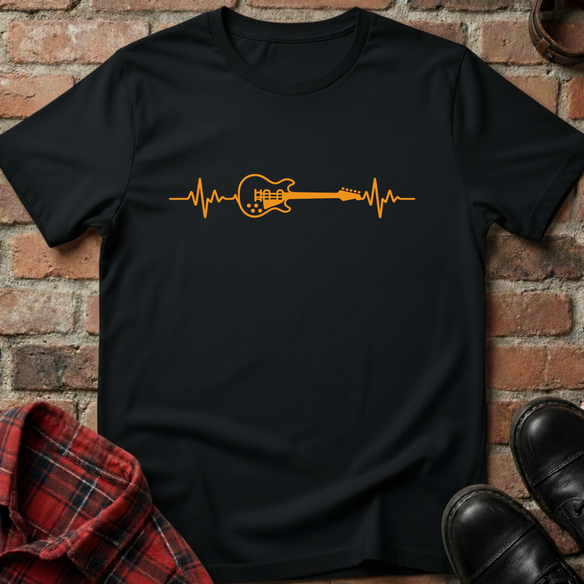 Black t-shirt with orange guitar heartbeat design on a brick background. Minimalist music apparel by pemuyo.