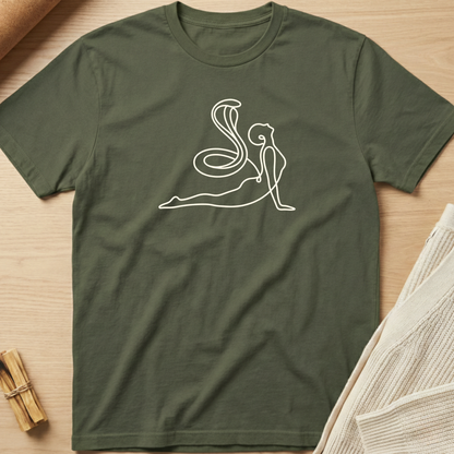Green t-shirt with a white line art design of a person and snake on a wooden surface. Minimalist yoga apparel by pemuyo.