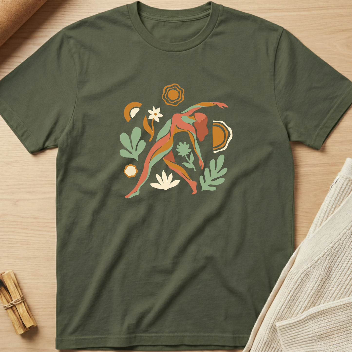 Green t-shirt with a colorful abstract design on a wooden surface. Minimalist yoga apparel by pemuyo.