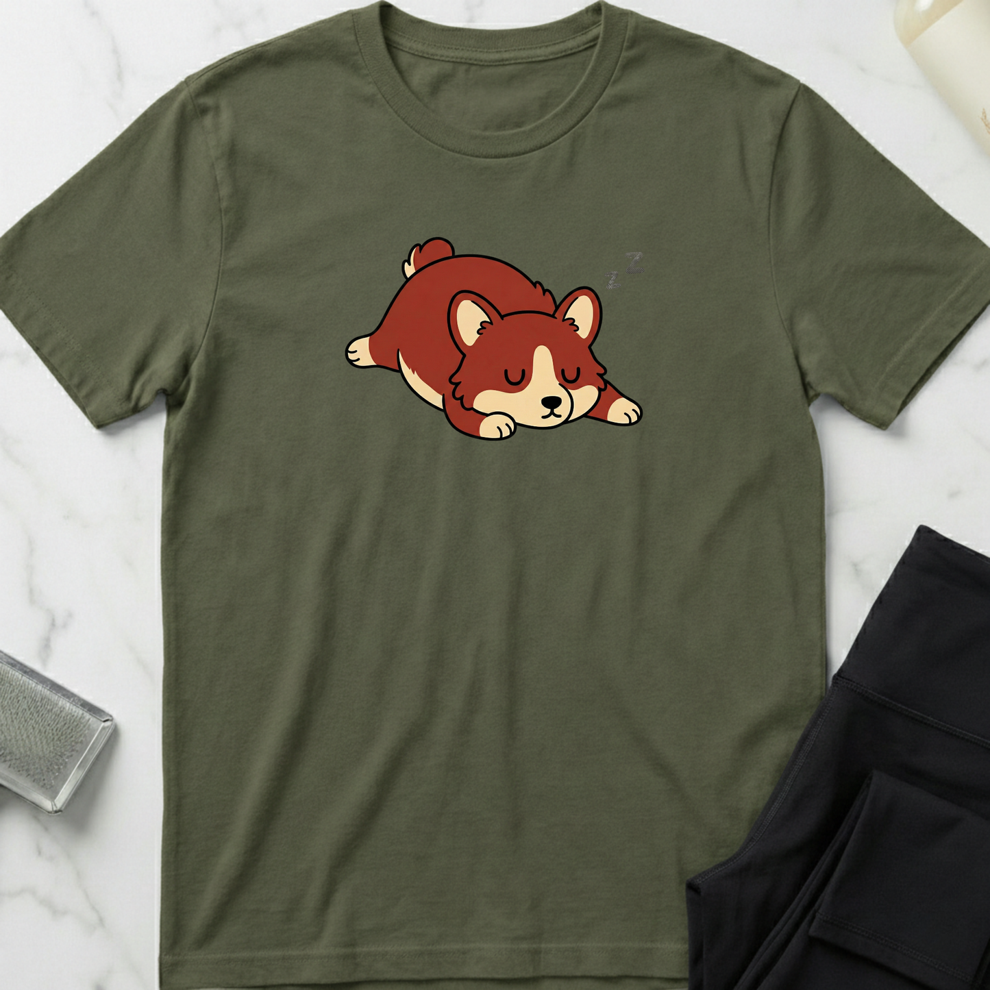 Green t-shirt with a cartoon dog design on a marble surface. Minimalist dog apparel by pemuyo.