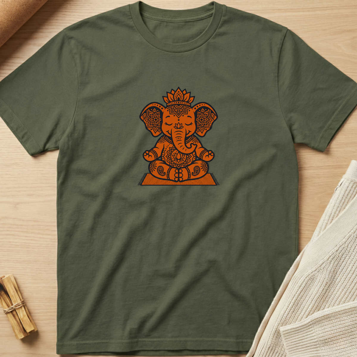 Green t-shirt with a colorful lotus flower design on a wooden surface. Minimalist yoga apparel by pemuyo.