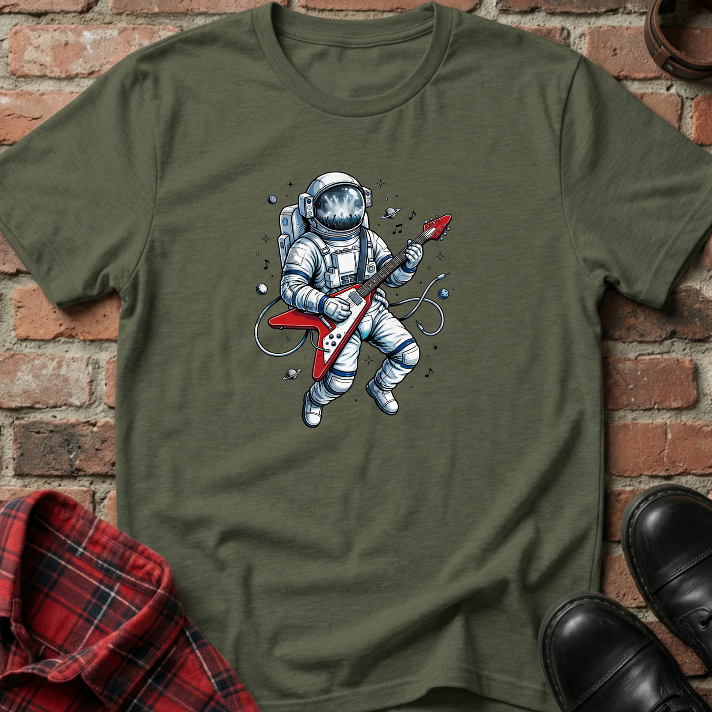 Green t-shirt with an astronaut playing a guitar graphic on a brick wall background. Minimalist music apparel by pemuyo.