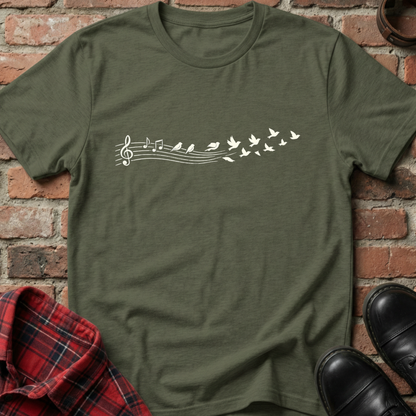 Green t-shirt with musical note and butterfly design on a brick wall background. Minimalist music apparel by pemuyo.