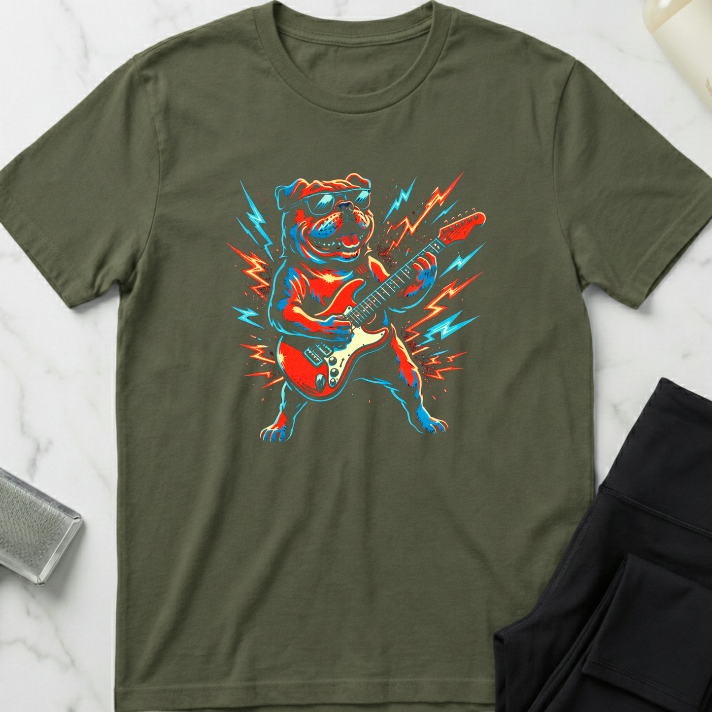 Green t-shirt with a colorful dog playing guitar graphic on a marble surface. Minimalist dog apparel by pemuyo.