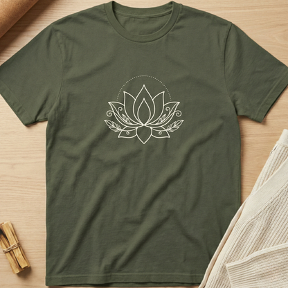 An olive green short-sleeve t-shirt with a white line art lotus flower graphic on the chest, laid flat on a light wood background with styled props. Minimalist yoga apparel by pemuyo.