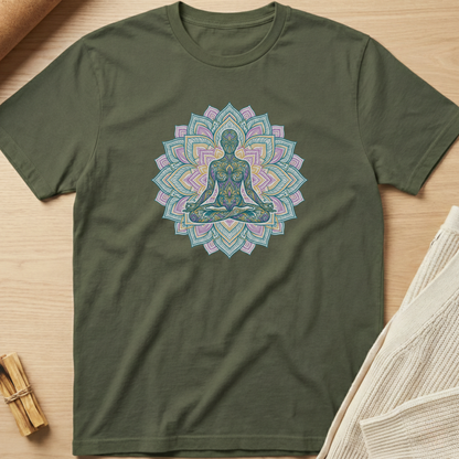Green t-shirt with a colorful mandala design featuring a meditating figure on a wooden surface. Minimalist yoga apparel by pemuyo.
