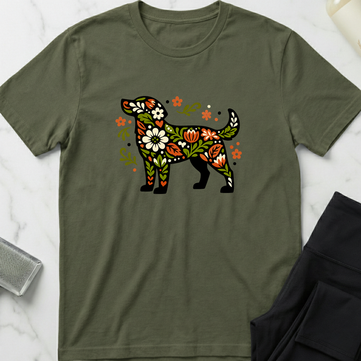 Green t-shirt with a colorful floral dog design on a marble surface. Minimalist dog apparel by pemuyo.