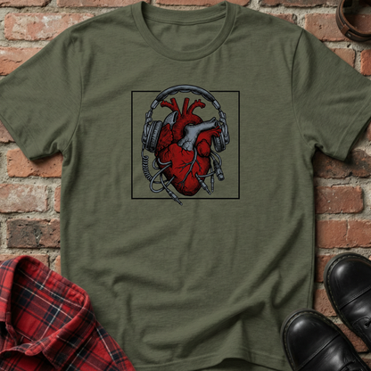 Green t-shirt with a heart and headphones design on a brick background. Minimalist music apparel by pemuyo.