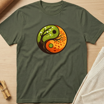 Green t-shirt with a yin yang design featuring nature elements on a wooden surface. Minimalist yoga apparel by pemuyo.