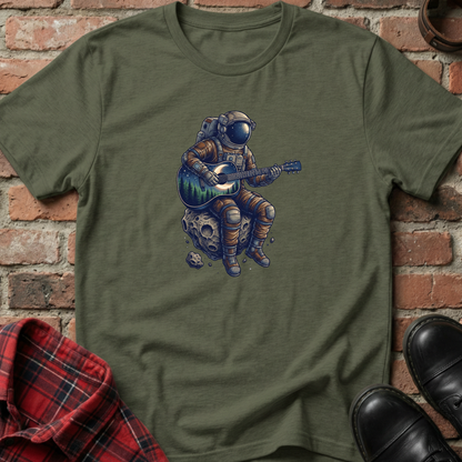 Green t-shirt with an astronaut playing guitar design against a brick wall. Minimalist music apparel by pemuyo.