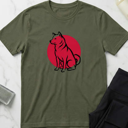 Green t-shirt with a dog graphic on a red circle, placed on a marble surface. Minimalist dog apparel by pemuyo.
