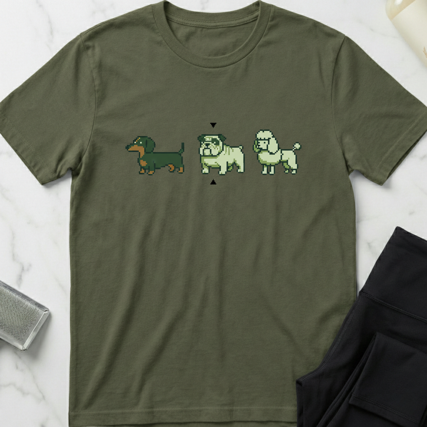 Green t-shirt with pixelated dog illustrations on a marble surface. Minimalist dog apparel by pemuyo.