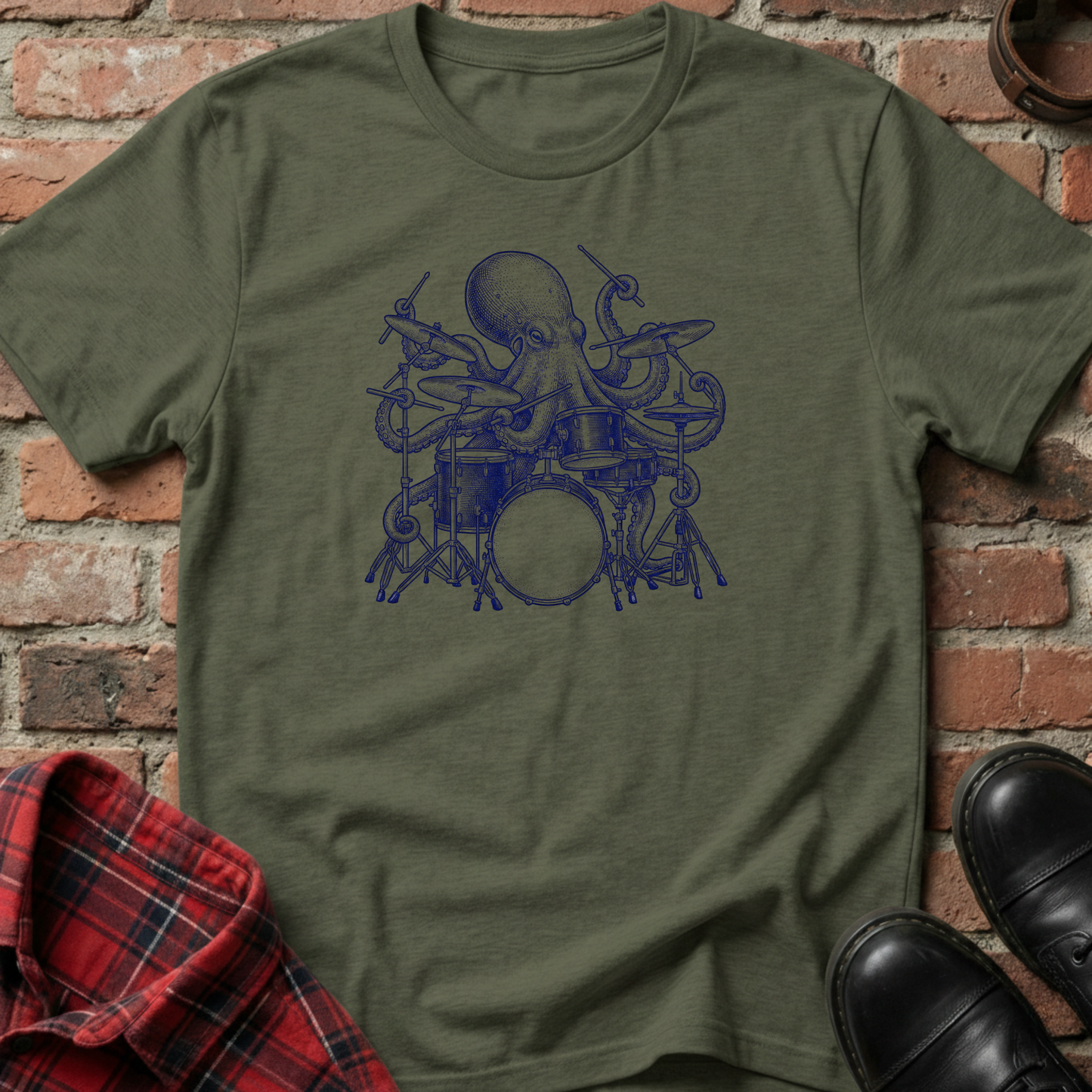 Green t-shirt with blue octopus playing drums graphic on a brick background. Minimalist music apparel by pemuyo.