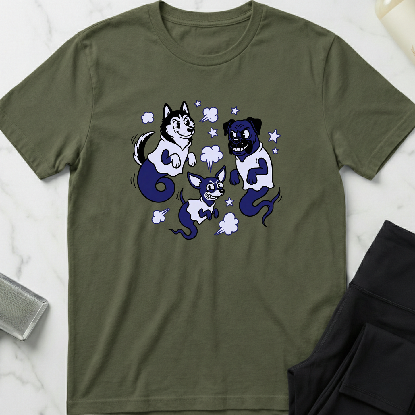 Green t-shirt with cartoon dog design on a marble surface. Minimalist dog apparel by pemuyo.