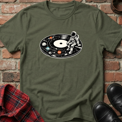 Green t-shirt with an astronaut design on a brick wall background. Minimalist music apparel by pemuyo.