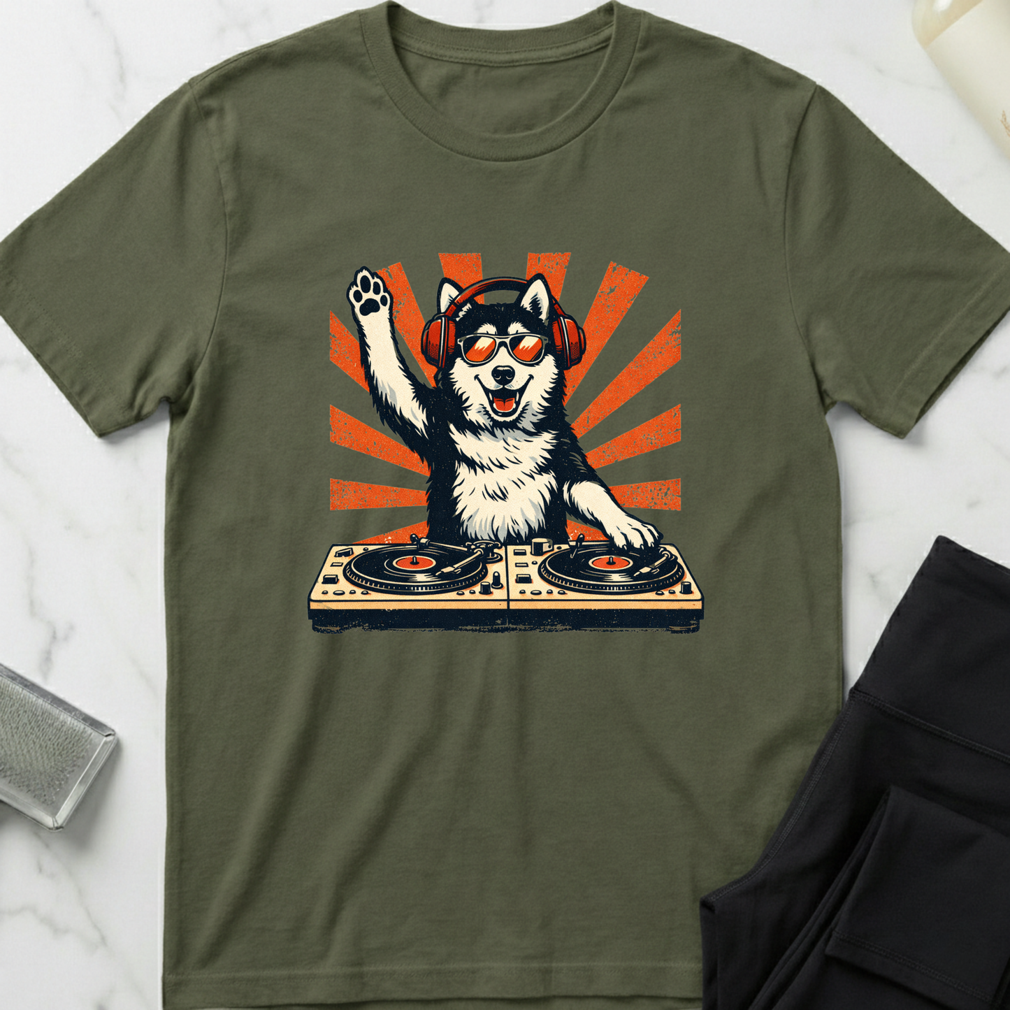 Green t-shirt with a dog DJ graphic on a white marble surface. Minimalist dog apparel by pemuyo.