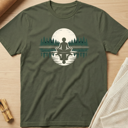Green t-shirt with a meditation graphic on a wooden surface. Minimalist yoga apparel by pemuyo.