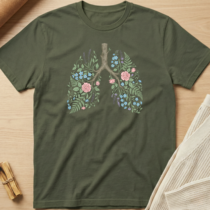 Green t-shirt with floral lung design on a wooden surface. Minimalist yoga apparel by pemuyo.