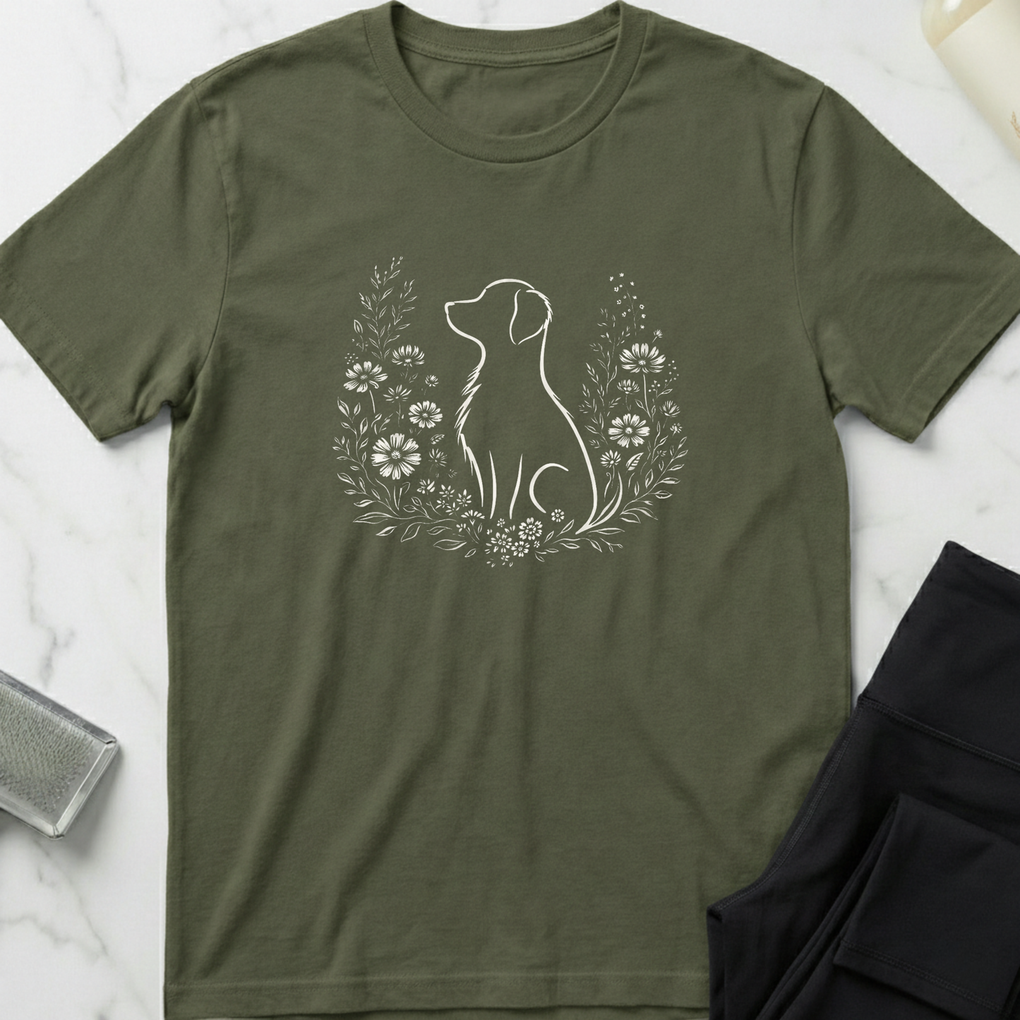 Green t-shirt with a dog and floral design on a marble surface. Minimalist dog apparel by pemuyo.