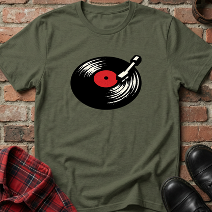 Green t-shirt with a vinyl record design on a brick background. Minimalist music apparel by pemuyo.