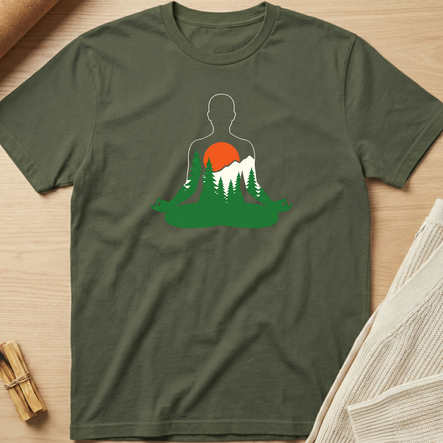 Green t-shirt with a nature-themed graphic on a wooden surface. Minimalist yoga apparel by pemuyo.