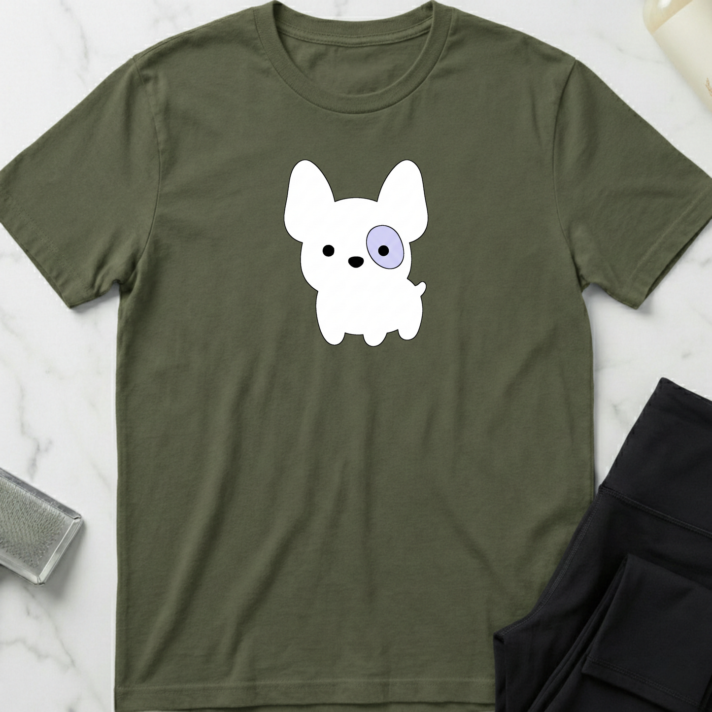 Green t-shirt with a white dog graphic on a marble surface. Minimalist dog apparel by pemuyo.