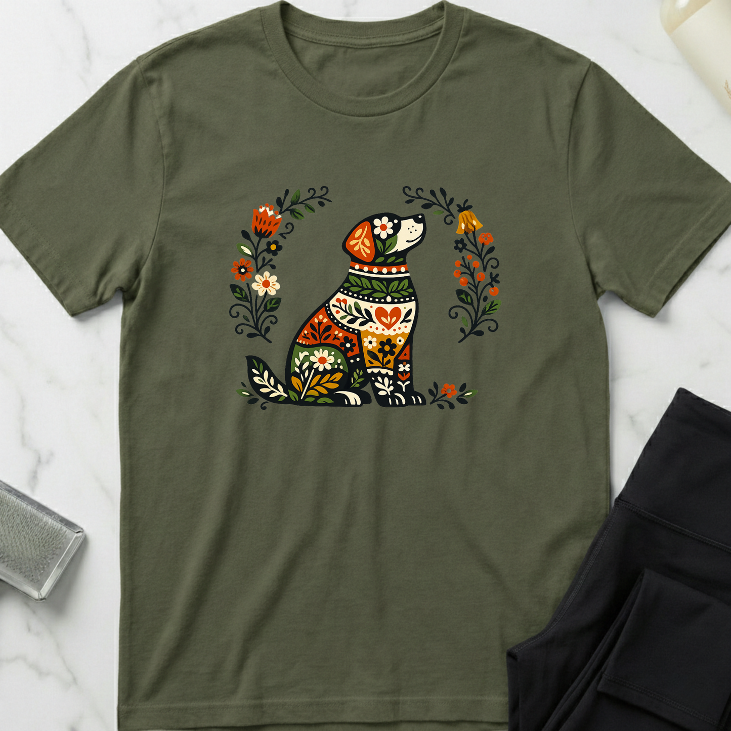 Green t-shirt with a colorful dog and floral design on a marble surface. Minimalist dog apparel by pemuyo.