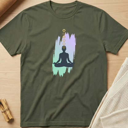 Green t-shirt with a meditation graphic on a wooden surface. Minimalist yoga apparel by pemuyo.