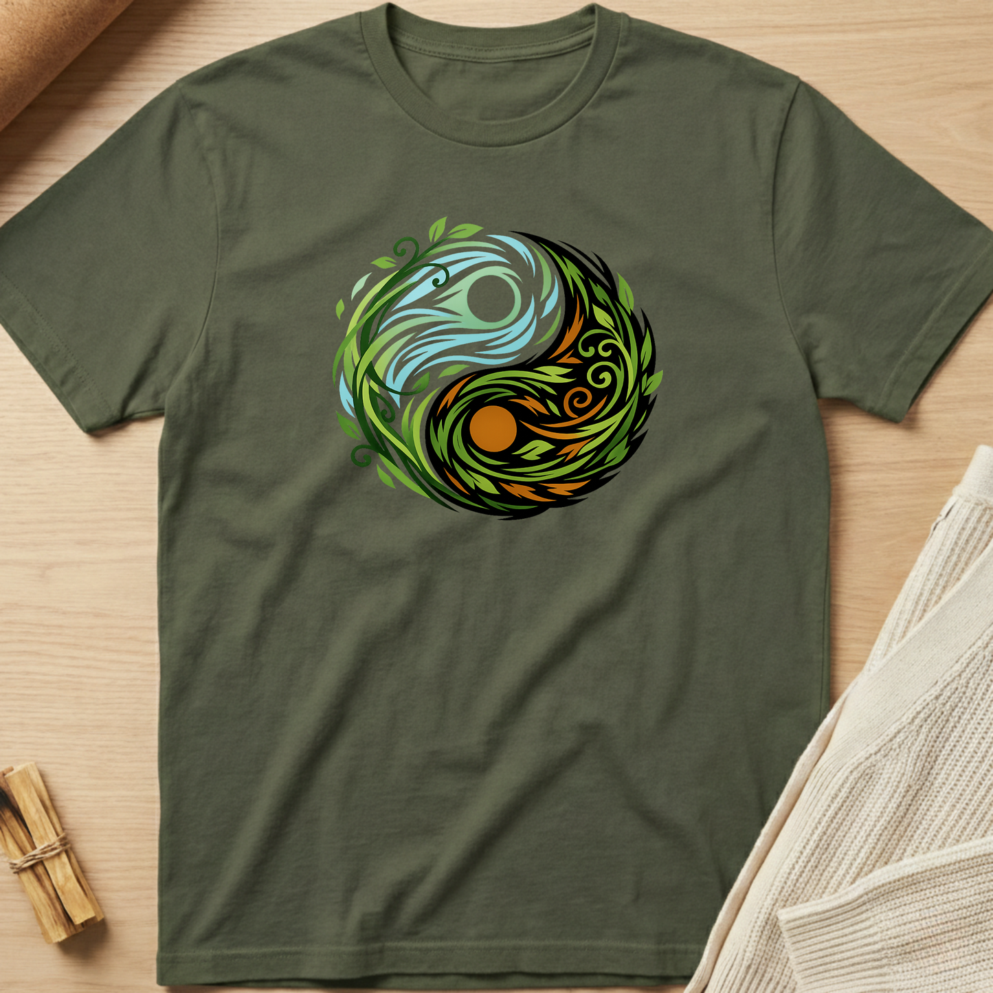 Green t-shirt with a colorful circular design on a wooden surface. Minimalist yoga apparel by pemuyo.