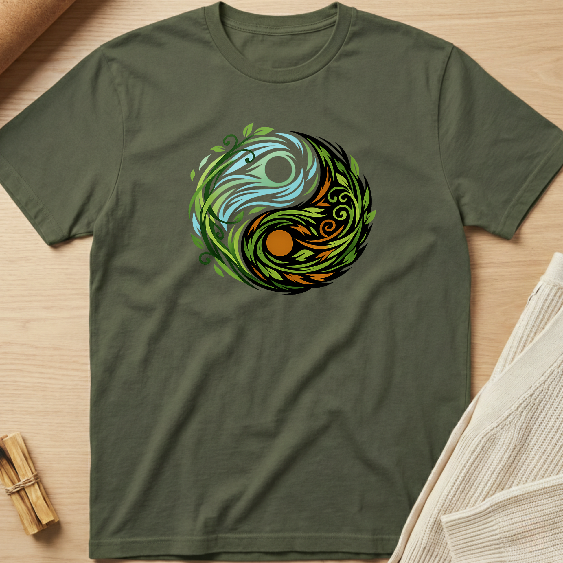 Green t-shirt with a colorful circular design on a wooden surface. Minimalist yoga apparel by pemuyo.